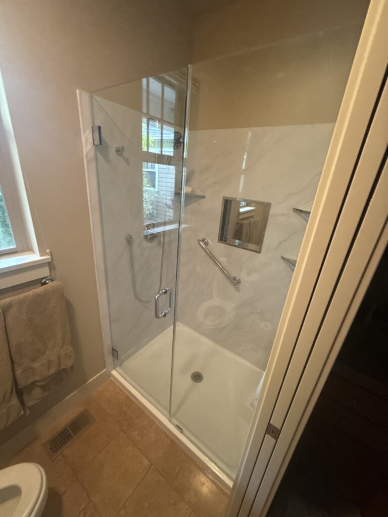 Modern tub to shower conversion with glass door and polymarm finish in Eugene, Oregon.