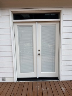 Backyard French doors with white paint and double pane windows in Eugene, Oregon. 