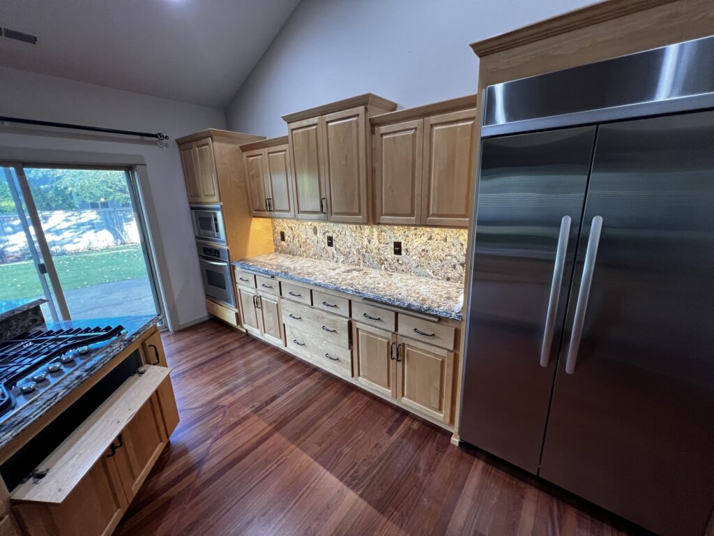 modern kitchen remodel with granite countertops, luxury vinyl plank flooring, custom cabinets and stainless steel appliances in Eugene, Oregon. 