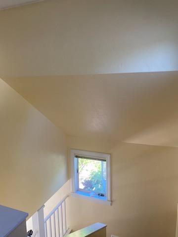 Interior painting in Veneta, Oregon with warm neutral walls, white stair railing, trim, and a finished upstairs landing.