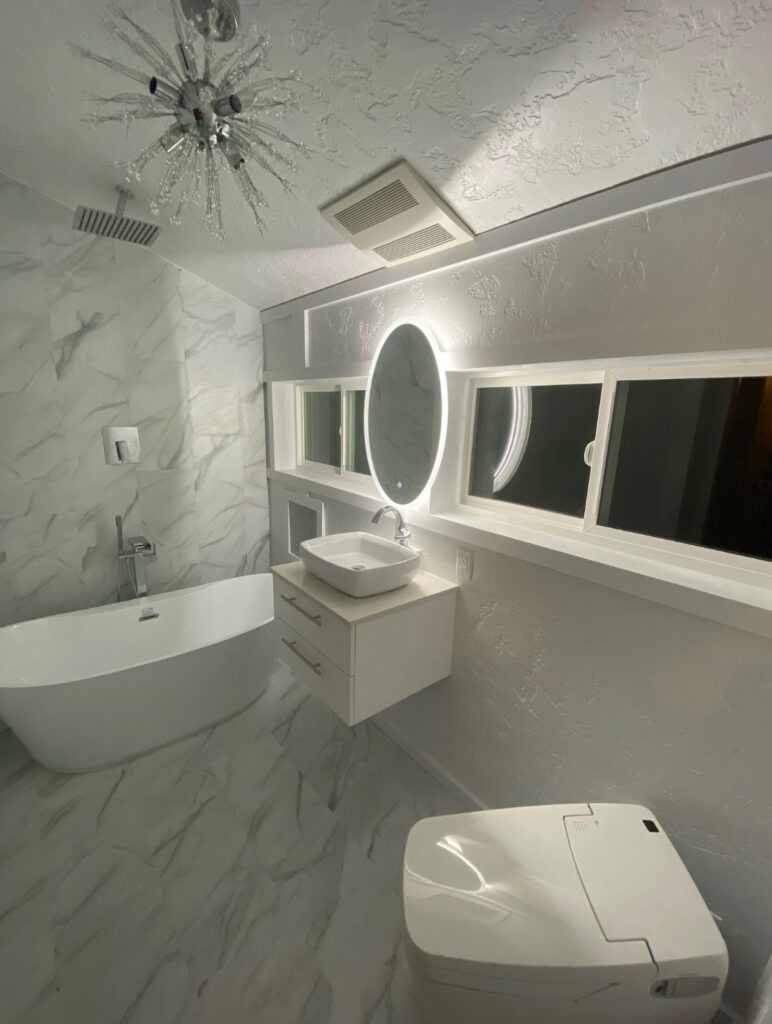 Free standing tub with single vanity, LED lighting around mirror and tile flooring, in South Eugene, Oregon.