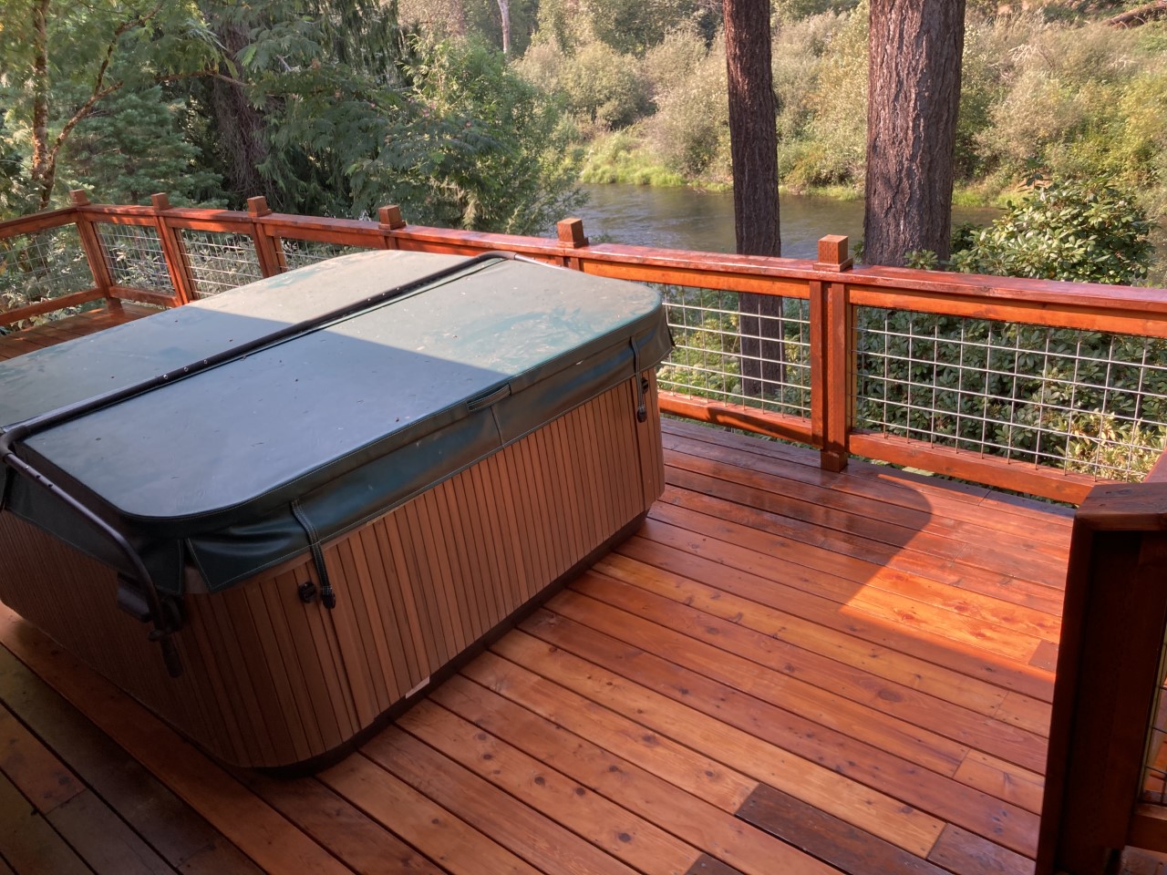 Treated cedar decking stained red, hot tub on the river in Springfield, Oregon.